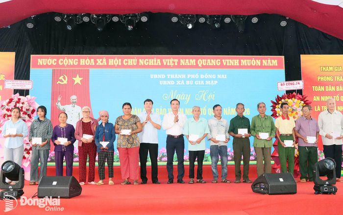 Phó Giám đốc Báo và Phát thanh, Truyền hình Đồng Nai Hoàng Bình Long và Phó Chánh Văn phòng Thành ủy Nguyễn Xuân Cường tặng quà cho hộ nghèo, gia đình chính sách xã Bù Gia Mập. Ảnh: Quang Minh