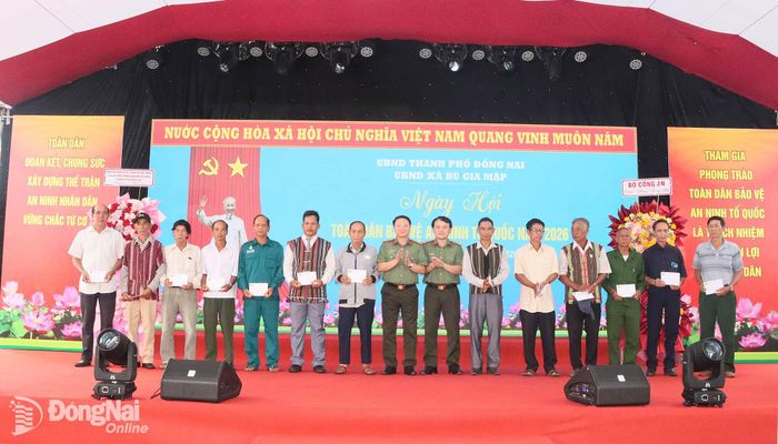 Đại tá Nguyễn Thanh Bình, Phó Cục trưởng Cục Xây dựng phong trào bảo vệ an ninh Tổ quốc, Bộ Công an và Đại tá Nguyễn Chí Toàn, Phó Giám đốc Công an thành phố, Phó Trưởng ban Chỉ đạo thành phố tặng quà cho già làng, người có uy tín xã Bù Gia Mập. Ảnh: Quang Minh