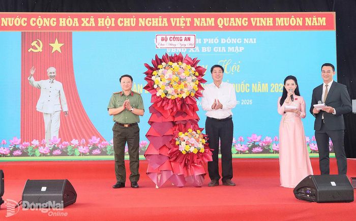 Đại tá Nguyễn Thanh Bình, Phó Cục trưởng Cục Xây dựng phong trào bảo vệ an ninh Tổ quốc, Bộ Công an tặng hoa chúc mừng ngày hội. Ảnh: Quang Minh