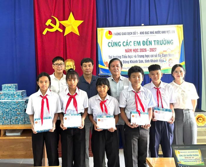 Đại diện Phòng Giao dịch số 1 và Ban Giám hiệu nhà trường trao quà cho các học sinh.