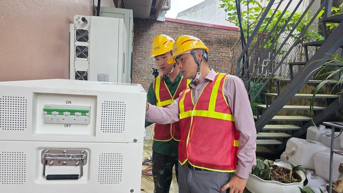Cán bộ kỹ thuật Chi nhánh Viettel Construction Lai Châu kiểm tra tủ điện và bộ biến tần (Inverter) sau khi hoàn thiện lắp đặt hệ thống điện mặt trời tại nhà nghỉ Bình Long (phường Tân Phong).