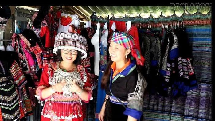 Du khách trải nghiệm, tìm hiểu trang phục truyền thống của đồng bào Mông.