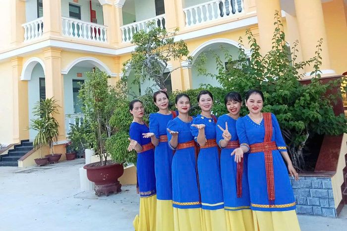 Nụ cười rạng rỡ của các thành viên đội múa Chăm trong sắc phục xanh thướt tha trước giờ biểu diễn