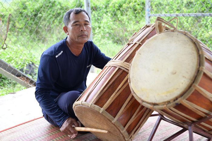 Tay phải cầm chiếc dùi gõ, còn những ngón tay trái nhảy múa uyển chuyển trên mặt trống