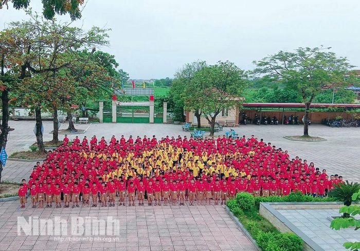 Học sinh Trường Tiểu học Nguyễn Hữu Tiến xếp hình lá cờ Tổ quốc trong một hoạt động ngoại khóa, giáo dục truyền thống quê hương của nhà trường.