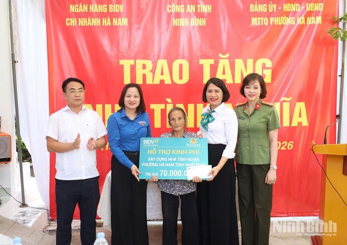 Đại diện Ngân hàng BIDV Chi nhánh Hà Nam, Tỉnh đoàn Ninh Bình, Phòng Công tác chính trị và cấp ủy, chính quyền địa phương trao biển hỗ trợ kinh phí xây dựng nhà cho gia đình bà Ngô Thị Liên.