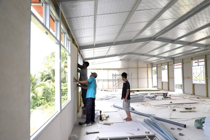 Tại công trình ở thôn Phú Hữu (thuộc gói thầu số 5) cơ bản thành hình, công nhân đang hoàn thiện không gian sinh hoạt ở tầng trên.