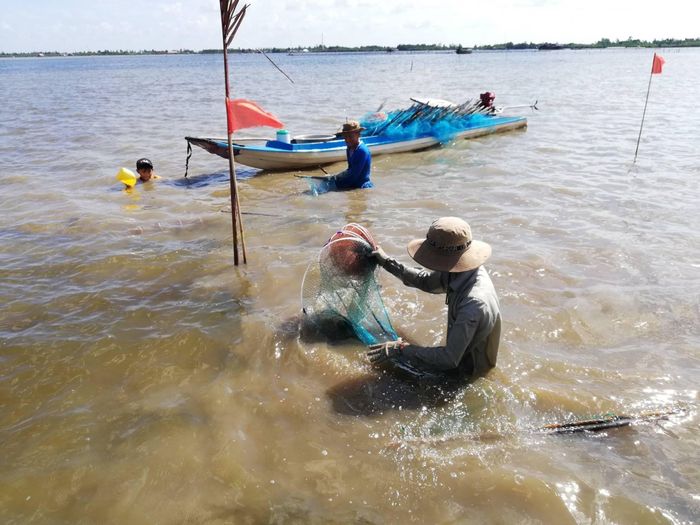 Người dân đánh bắt thủy sản trên mặt đầm, lưu giữ sinh kế truyền thống gắn với con nước qua nhiều thế hệ. Ảnh: Tường Quang