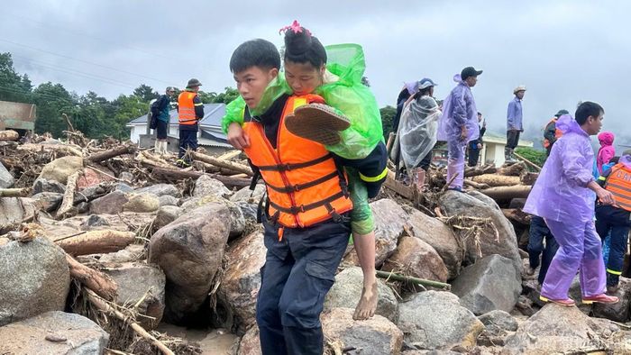Lực lượng Công an hỗ trợ đưa người dân mắc kẹt ra khỏi khu vực nguy hiểm.