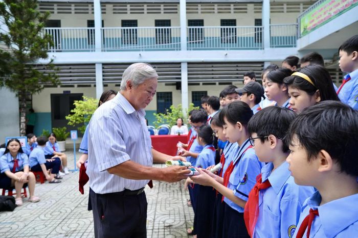 Học sinh nhận quà từ đại diện nhà trường.