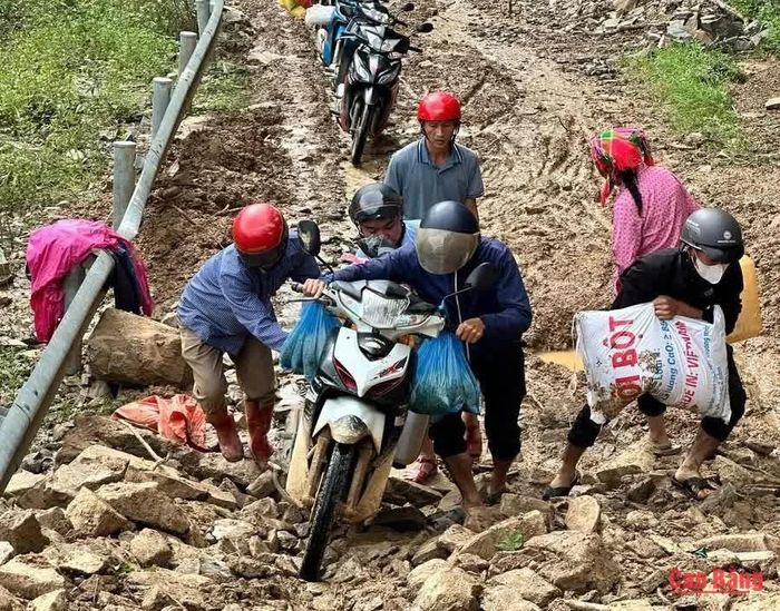  Địa hình dốc đứng, đường trơn khiến người dân phải hỗ trợ nhau khênh xe qua đoạn đường khó đi, bảo đảm an toàn trong hành trình.