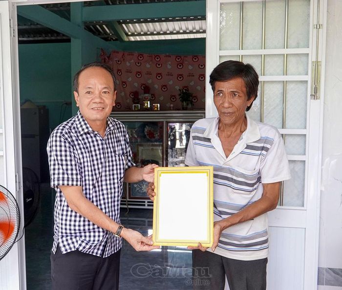  Đại diện UBND xã Hồng Dân trao quyết định bàn giao nhà đến đại diện gia đình bà Nguyễn Thị Chi.