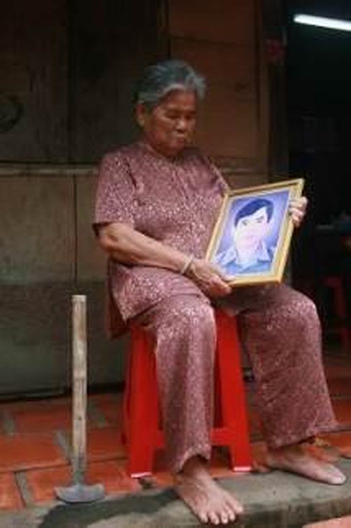Mẹ Việt Nam Anh hùng Trương Thị Trừ (SN 1936, ở xã Trung Lập Hạ, Củ Chi cũ) bên di ảnh con và chiếc cuốc đào địa đạo năm xưa