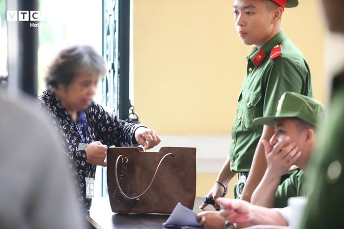 Cảnh sát kiểm tra giấy tờ người vào khu vực xử án.