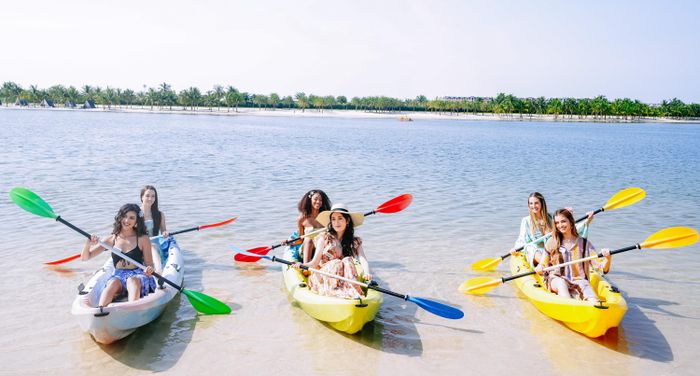 Các người đẹp chèo kayak theo nhóm. Sau khi được hướng dẫn kỹ thuật và trang bị dụng cụ, họ cùng nhau xuống nước, phối hợp điều khiển những chiếc kayak trên biển.