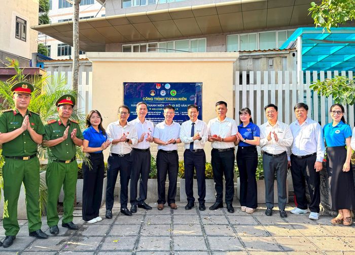 Lãnh đạo phường Kim Liên, Bệnh viện Da liễu Trung ương và Công an phường thực hiện nghi thức gắn biển công trình “Hàng cây thanh niên - Lối đi bộ văn minh”. Ảnh: Nguyên Bảo