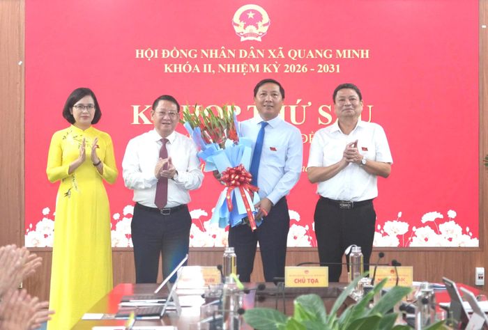 Lãnh đạo xã Quang Minh tặng hoa tri ân đồng chí Nguyễn Thanh Liêm - Thành ủy viên, nguyên Bí thư Đảng ủy xã Quang Minh. Ảnh: Phạm Hùng