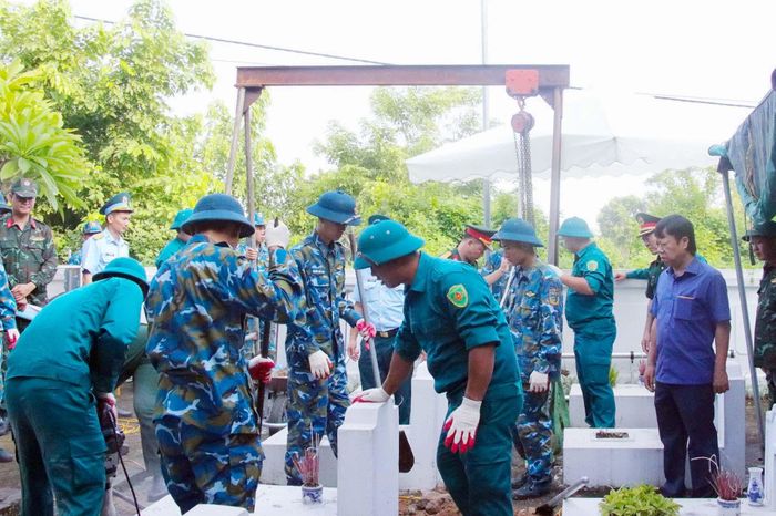 Các lực lượng chức năng thực hiện lấy mẫu tại các phần mộ liệt sĩ chưa xác định được danh tính. Ảnh: HĐ