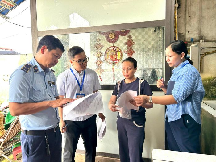 Đại diện một đơn vị kinh doanh cá xuất trình giấy tờ liên quan cho Đoàn kiểm tra. Ảnh: Trần Oanh.