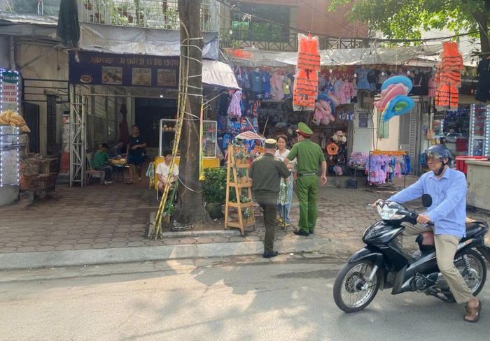 Lực lượng Công an phường Khương Đình tuyên truyền hộ kinh doanh chấp hành quy định về trật tự đô thị. Ảnh: Hậu Lộc