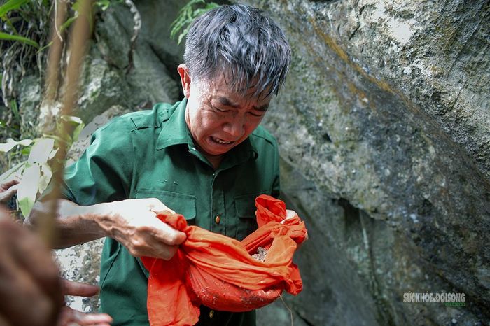 Ông Hùng bật khóc khi nhìn thấy phần di cốt đồng đội vừa được tìm thấy. Ảnh: Tuấn Anh