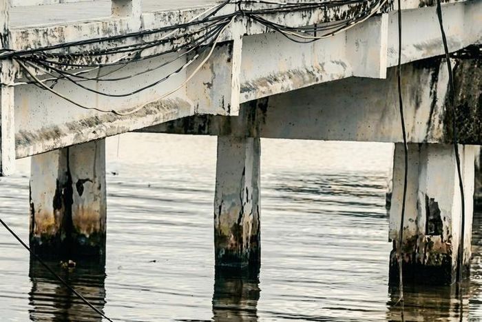 Một số vị trí chân cầu treo Rạch Ráng bị nứt, bong tróc lớp bê tông, lộ cốt thép trước khi được sửa chữa. ( Ảnh: do người dân cung cấp)