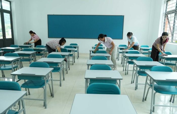 Các giáo viên lau dọn bàn ghế tại các lớp học ở Trường Phổ thông nội trú liên cấp Tiểu học và Trung học cơ sở Phong Thổ. Nguyễn Oanh-TTXVN