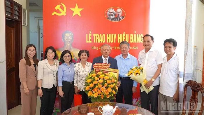 Bí thư Tỉnh ủy Đồng Tháp Ngô Chí Cường trao Huy hiệu Đảng và tặng hoa chúc mừng đồng chí Võ Hồng Nhân. (Ảnh: Hữu Nghĩa)