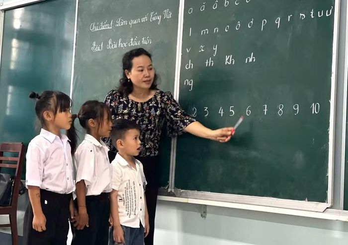 Cô Nguyễn Thị Lan, giáo viên chủ nhiệm lớp 1A, Trường Phổ thông nội trú Tiểu học và THCS Ia Mơ giúp học sinh làm quen với chương trình.