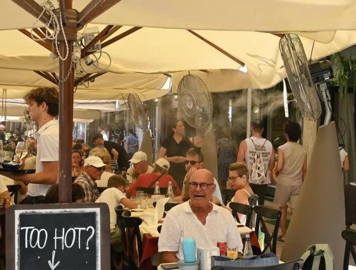 Một nhà hàng ở Italy sử dụng quạt phun sương để giải nhiệt cho khách hàng ngày 2/8, giữa lúc nắng nóng cực đoan. (Nguồn: Tân Hoa xã)