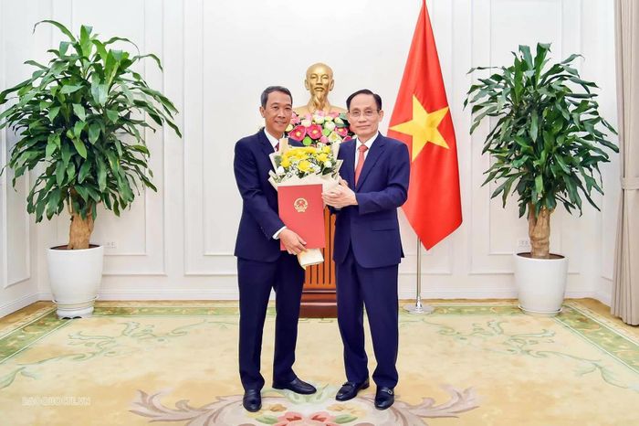 Bộ trưởng Lê Hoài Trung tặng hoa chúc mừng đồng chí Nguyễn Trung Hiếu. (Ảnh: Quang Hòa)