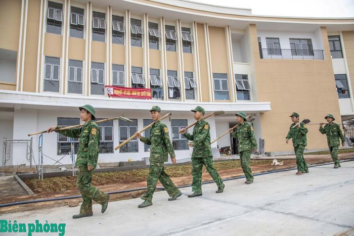 Đồn Biên phòng cửa khẩu quốc tế Thuận An triển khai lực lượng ra công trường thi công trường nội trú liên cấp, bên cạnh là khu nhà hành chính đã hoàn thiện. Ảnh: Lê Chương
