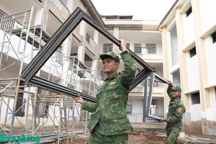 BĐBP hỗ trợ vận chuyển khung cửa để hoàn thiện khu hành chính của trường. Ảnh: Lê Chương