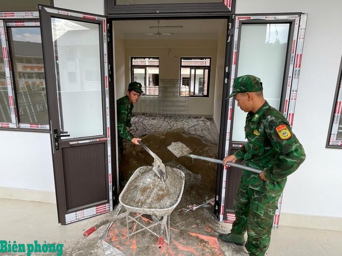Cán bộ, chiến sĩ Bộ đội Biên phòng tham gia hoàn thiện các hạng mục sân trường, góp sức đưa công trình về đích đúng kế hoạch. Ảnh: Văn Trai