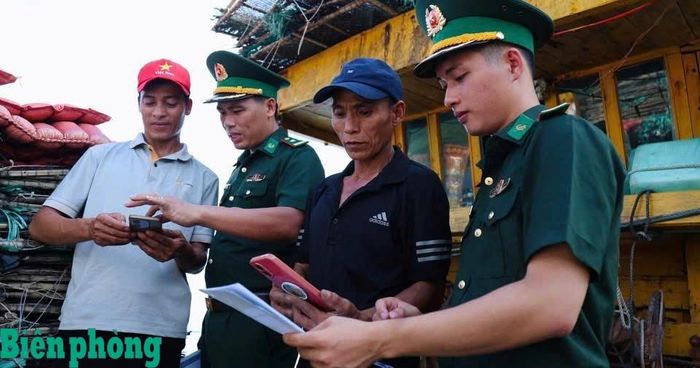 Cán bộ Đồn Biên phòng Cửa Sót hướng dẫn ngư dân cài đặt ứng dụng eCDT VN trên điện thoại thông minh. Ảnh: Đơn vị cung cấp