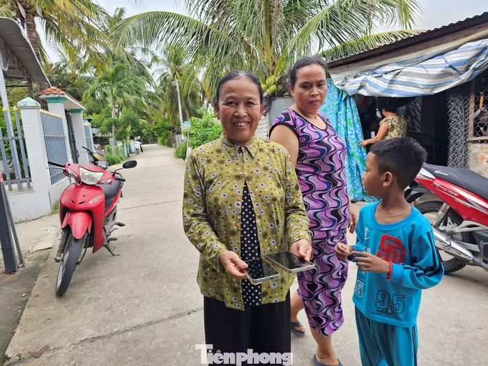 Người dân đồng bào Khmer được các sinh viên hỗ trợ tích hợp dữ liệu trên điện thoại.