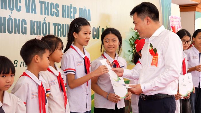 Ông Nguyễn Ngọc Quỳnh - Thành viên HĐQT BSR trao quà cho các em học sinh Trường Tiểu học và THCS Hiệp Hòa.