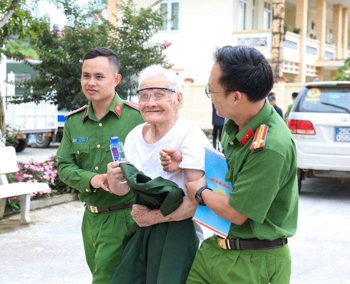 Người dân vui vẻ được các cán bộ chiến sĩ giúp đỡ.