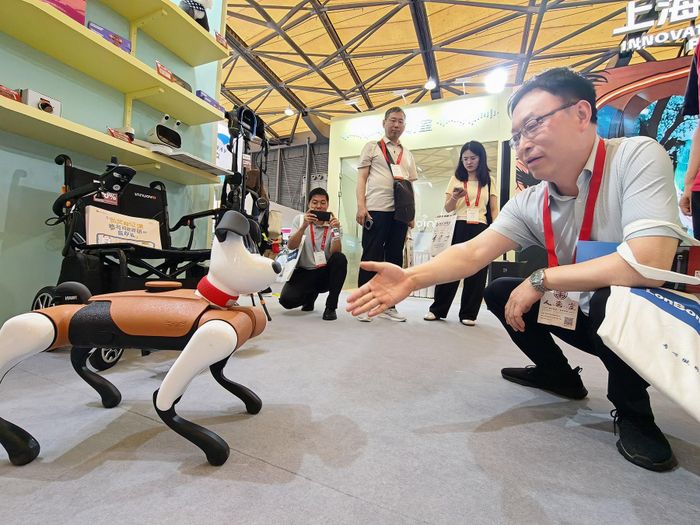 Khách thăm quan tương tác với một chú chó robot trong Triển lãm Quốc tế về Chăm sóc Người cao tuổi, Y học Phục hồi chức năng và Chăm sóc sức khỏe Thượng Hải 2026. Ảnh: China Daily