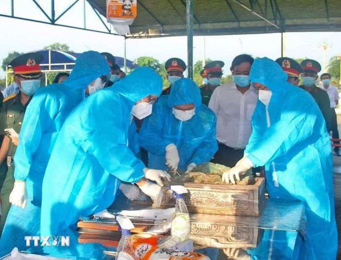 Thu thập mẫu sinh phẩm để xác định danh tính hài cốt liệt sỹ. (Ảnh: Huỳnh Anh/TTXVN)