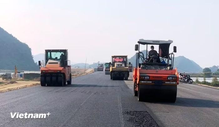 Nhà thầu thi công thảm nhựa mặt đường một dự án thành phần cao tốc. (Ảnh: Việt Hùng/Vietnam+)