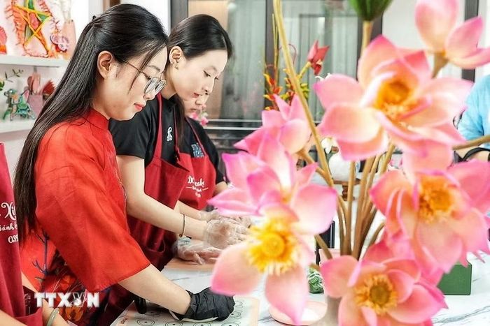 Các công đoạn tạo hình được thực hiện hoàn toàn thủ công, đòi hỏi sự tỉ mỉ để từng cánh hoa, nhụy, nụ và cành bằng bột tò he khi ghép lại có hình dáng tự nhiên, hài hòa. (Ảnh: Phạm Tuấn Anh/TTXVN)