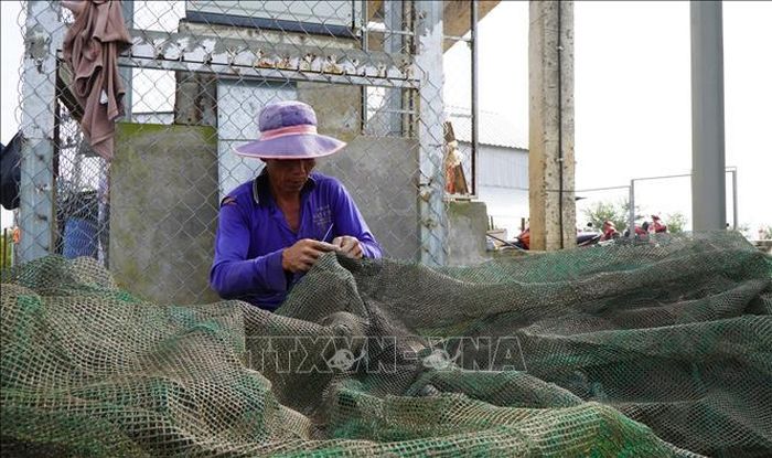 Nông dân ở vùng đầu nguồn của tỉnh Đồng Tháp vá lưới, chuẩn bị việc đánh bắt cá trong mùa nước nổi sắp đến.
