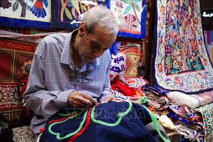 Ông Ahmed, nghệ nhân hơn 50 năm tuổi nghề, tập trung hoàn thiện một bức tranh khổ lớn. Ảnh: Hoàng Nhật/PV TTXVN tại Ai Cập