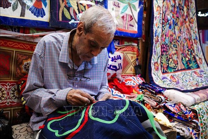 Ông Ahmed, nghệ nhân hơn 50 năm tuổi nghề, tập trung hoàn thiện một bức tranh khổ lớn. Ảnh: Hoàng Nhật/PV TTXVN tại Ai Cập
