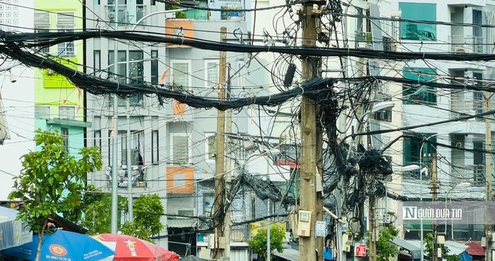 Không chỉ trụ điện, phía trên tuyến đường vẫn còn hệ thống dây dẫn điện và cáp viễn thông. Việc di dời đồng bộ hạ tầng kỹ thuật là một trong những phần việc cần hoàn tất để dự án đạt mục tiêu đề ra.