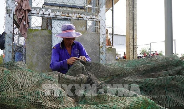 Nông dân ở vùng đầu nguồn của tỉnh Đồng Tháp vá lưới, chuẩn bị việc đánh bắt cá trong mùa nước nổi sắp đến. Ảnh: Nhựt An - TTXVN