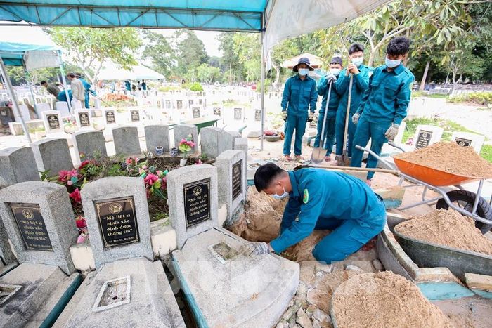 Cán bộ, chiến sĩ thực hiện công tác lấy mẫu hài cốt liệt sĩ tại Nghĩa trang liệt sĩ Đồi 82. Ảnh: Giang Phương - TTXVN