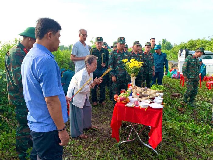 Bà Phạm Thị Gạo (em vợ của liệt sĩ Lâm Văn Sện) thắp hương tại khu vực tìm kiếm, quy tập hài cốt liệt sĩ (Ảnh: Vĩnh Nghị)