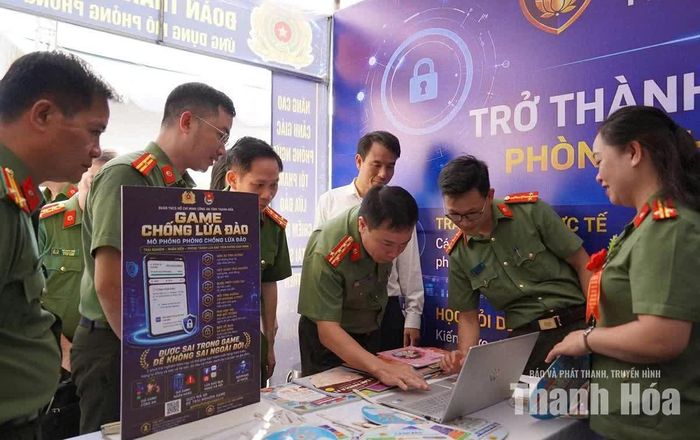 Đại tá Hoàng Quốc Việt, Giám đốc Công an tỉnh Thanh Hóa (ở giữa) trải nghiệm tiện ích chuyển đổi số trong Ngày hội Toàn dân bảo vệ an ninh Tổ quốc tại xã Hợp Tiến. Ảnh: Hà Phương